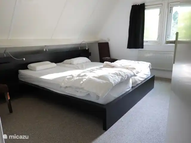 Het huisje heeft op de eerste verdieping een zeer ruime slaapkamer met een tweepersoons bed en veel kastruimte.